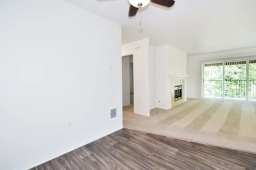 A room with a ceiling fan and a window with blinds.