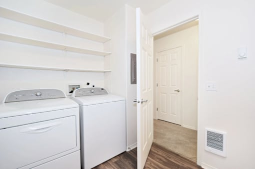 A white washing machine and dryer in a small laundry room.