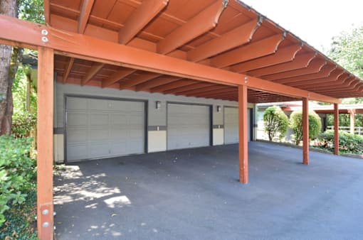 A covered parking area with two garage doors.