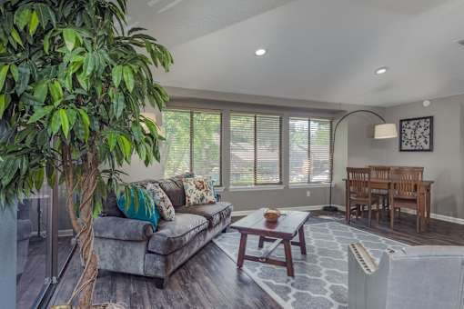 a living room with a couch and a table and a tree