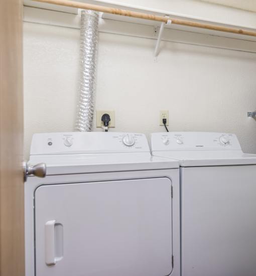 a white washer and dryer in a room with a door
