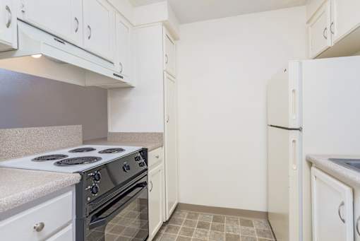 a kitchen with white cabinets and a stove and a refrigerator