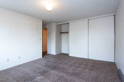 an empty living room with white walls and carpet