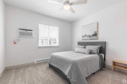 a bedroom with a bed and a ceiling fan