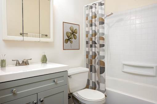 A bathroom with a toilet, sink, and shower.