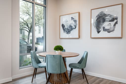 two maps of the world hang on the wall of a dining room with a table and four