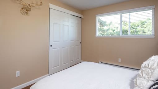 a bedroom with a bed and a white door and a window