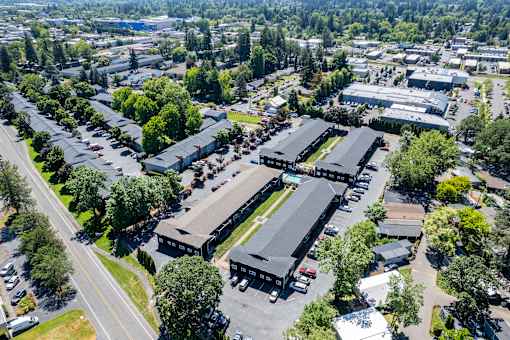 An aerial view of residential area with multiple buildings and parking lots.