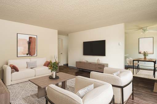 A living room with a white couch, a coffee table, and a television.