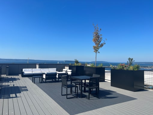 a terrace with tables and chairs and a view of the ocean