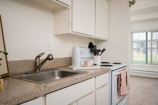 A kitchen with a sink, a toaster, and a window.