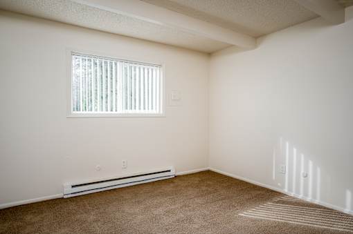 A room with a window and a wall-mounted air conditioner.