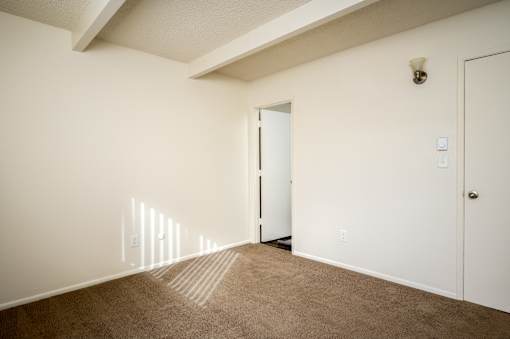 A room with a carpeted floor and a white door.