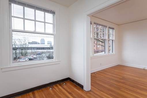 A room with a large window and a wooden floor.