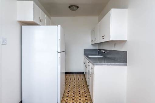 A kitchen with white appliances and cabinets.
