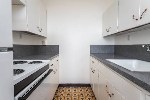A kitchen with white cabinets and a black stove top oven.