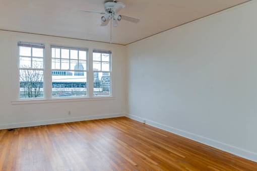 A room with a ceiling fan and a window overlooking a snowy landscape.