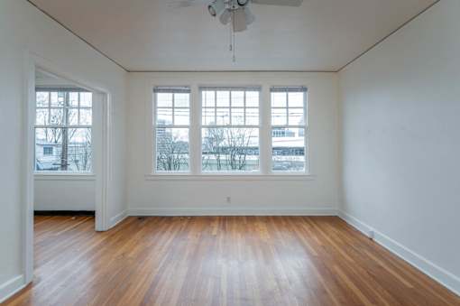 A room with wooden floors and a ceiling fan.