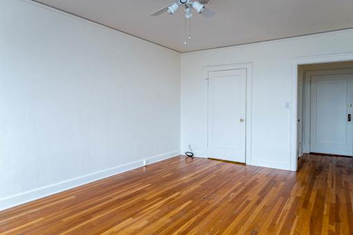 A room with a wooden floor and a ceiling fan.