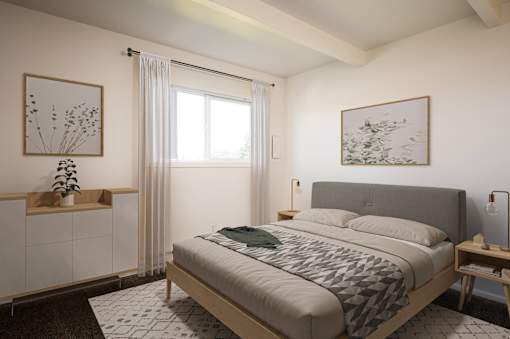 A bedroom with a large bed and a window with curtains.
