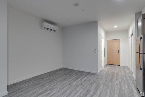 A room with a wooden floor and a door on the right side.