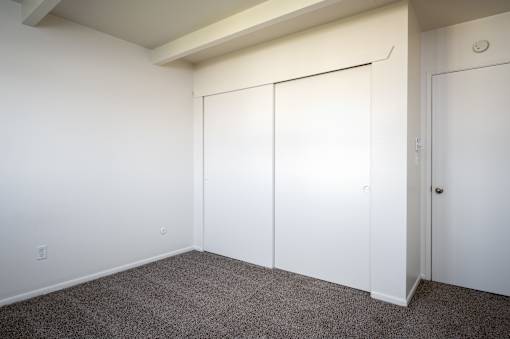 A room with a carpeted floor and white walls.