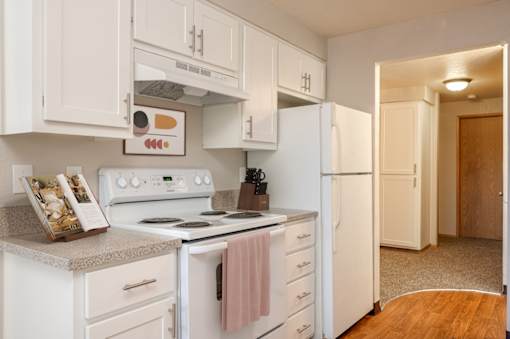 A kitchen with white cabinets and appliances.