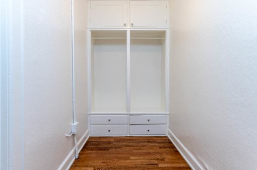 A white closet with a white door and two white drawers.