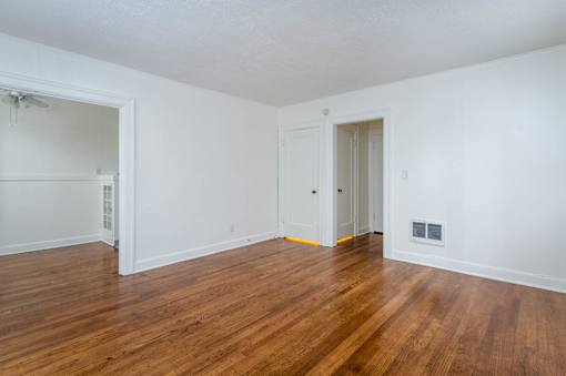 A room with wooden floors and white walls.