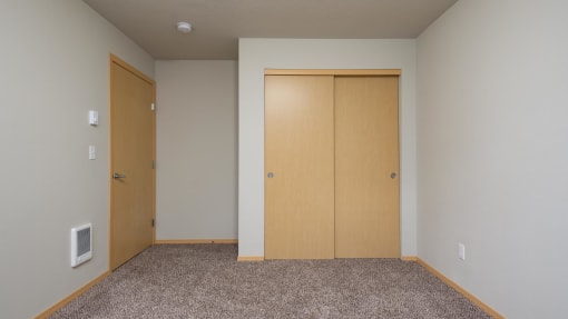 a bedroom with two doors and a carpeted floor