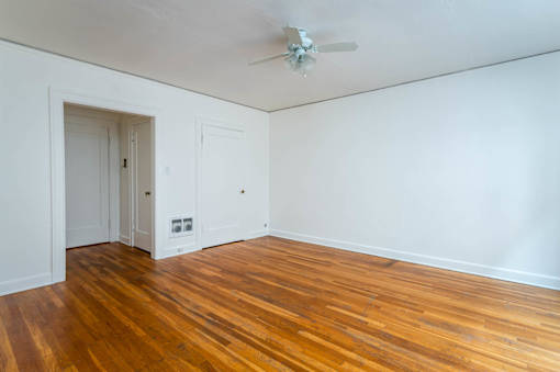 A room with a wooden floor and a ceiling fan.