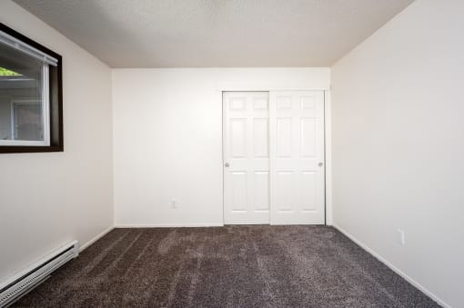 an empty room with carpet and a door