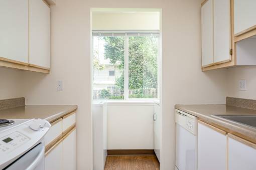 A kitchen with white appliances and cabinets.