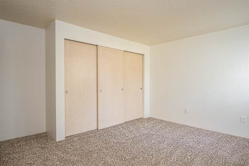 A room with two doors and carpeted floor.