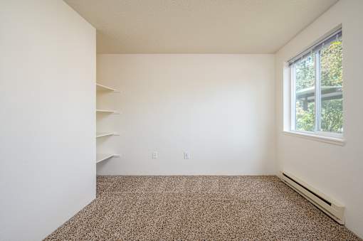 A room with a carpeted floor and a window.