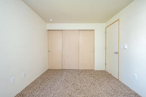 A room with a carpeted floor and a white wall.