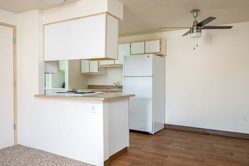 A kitchen with white cabinets and a white refrigerator.