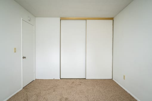 an empty room with white walls and a carpet
