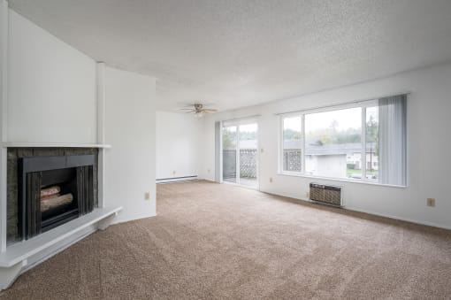 an empty living room with a fireplace and a window