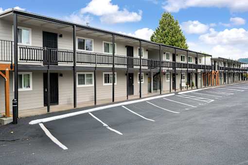 A parking lot in front of a row of townhouses.