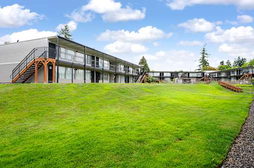 A modern building with a green lawn in front.