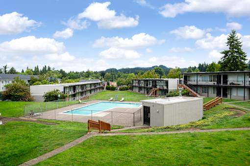 A large building complex with a pool in the foreground.