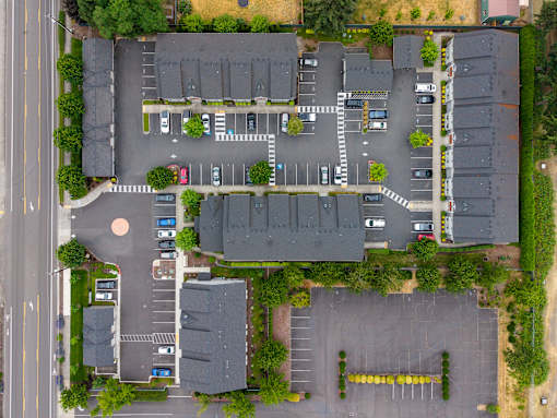 A parking lot with cars and a building in the background.