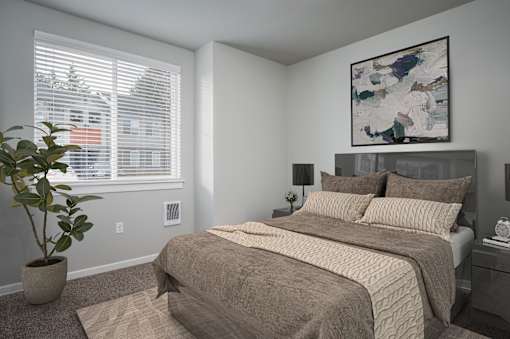 A bedroom with a large bed and a potted plant.