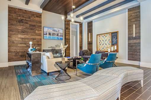 A living room with a white couch and blue chairs at Crabtree Lakeside Apartments, Raleigh, NC