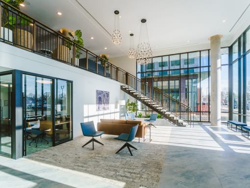 the lobby of a building with a staircase and a living room