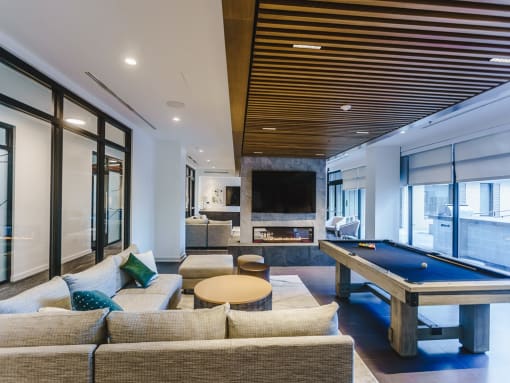a game room with a pool table and couches