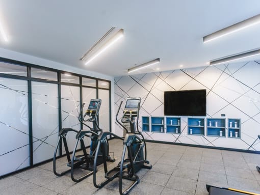 a workout room with weights and a television