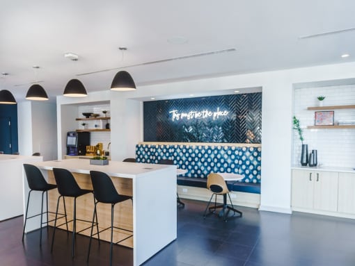 a kitchen with a bar and chairs and a blue and white wall