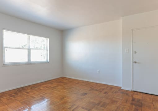 A room with a wooden floor and a window.